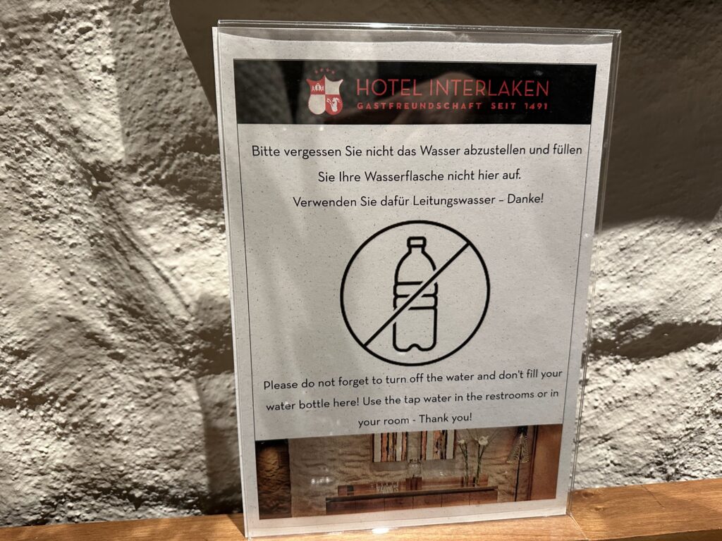 Aviso para encher as garrafinhas na pia do quarto no hotel em Interlaken I Foto: Andréa Reis